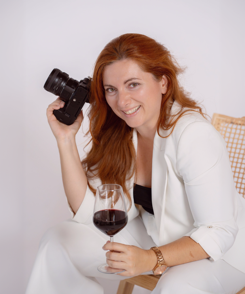 Tea Mamika, fotografkinja i kreatorica sadržaja za vinarije, s fotoaparatom i čašom vina